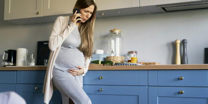 Pregant woman with cramps making call